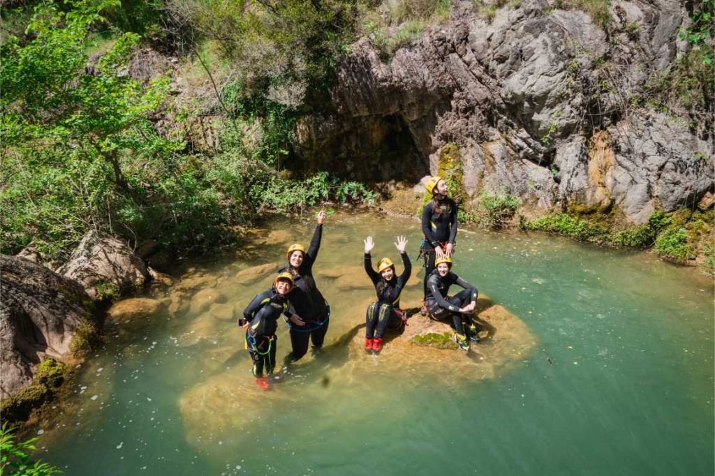 Guide helping a guest across a rock ledge